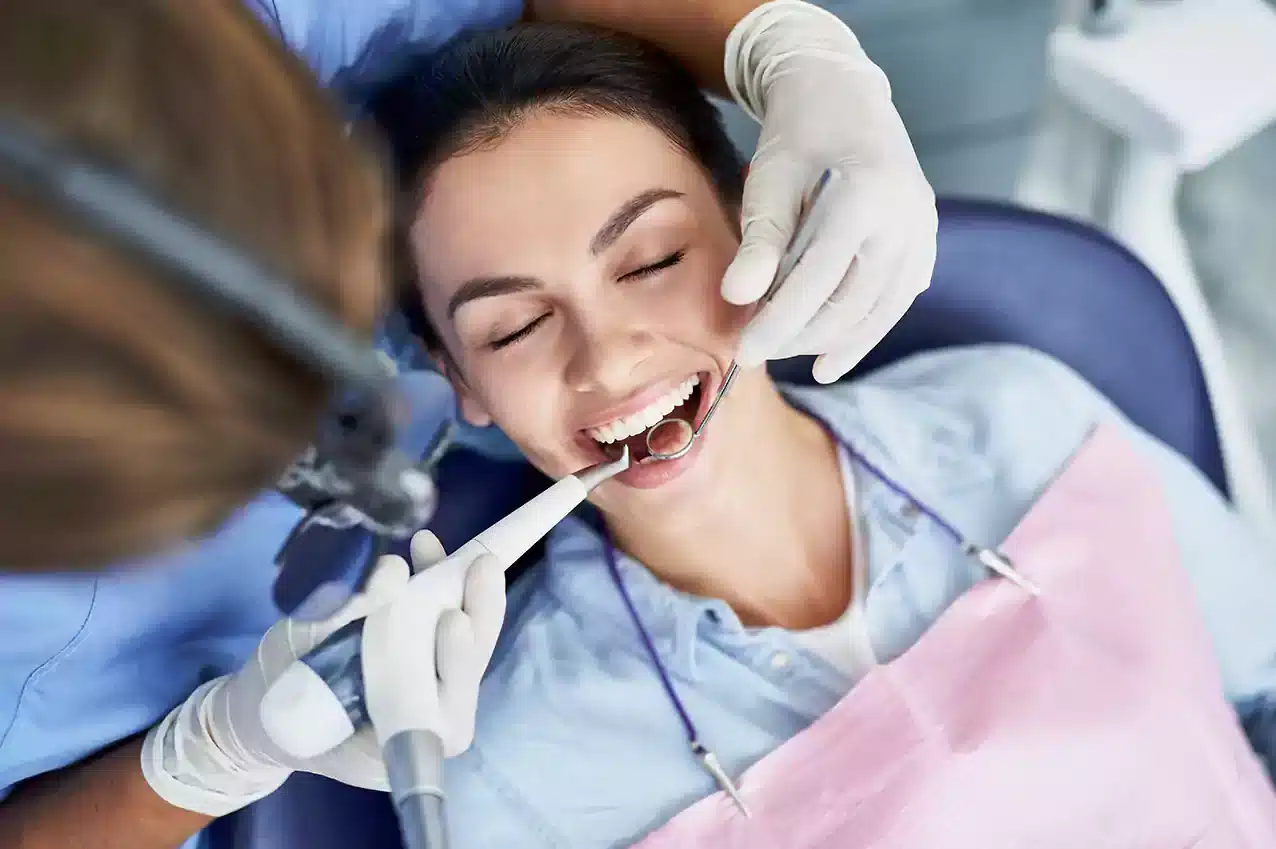 Chica sonriendo durante una limpieza dental - Coomeva Salud Oral